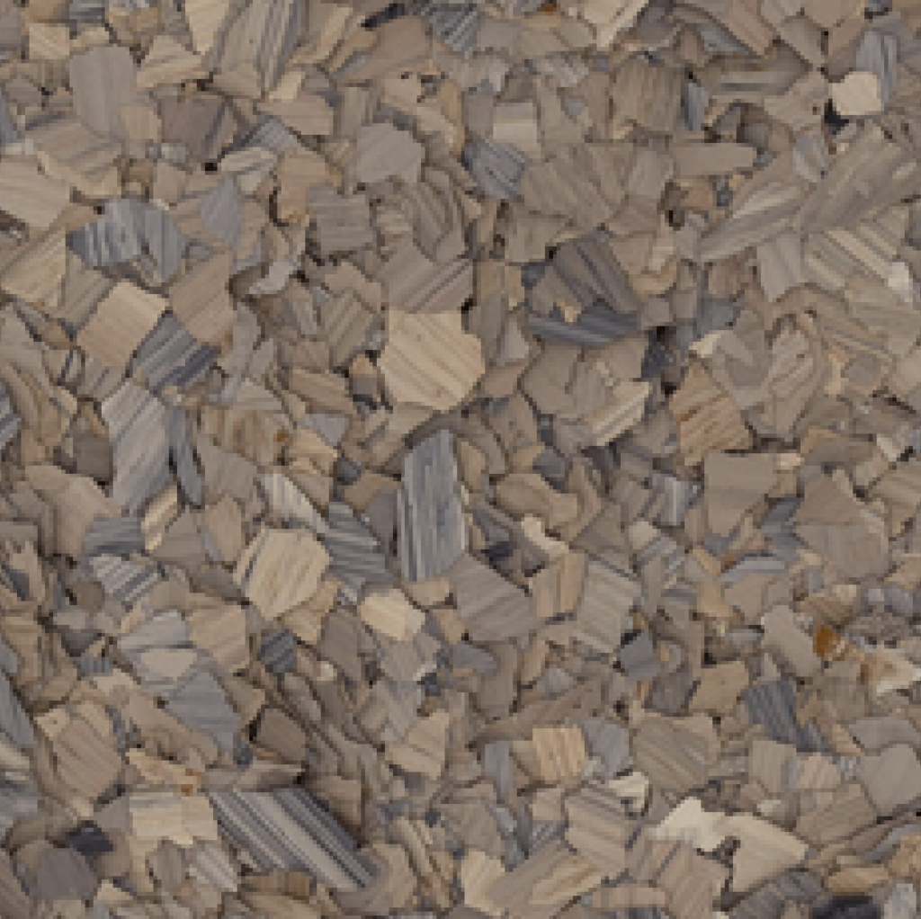 The image shows a close-up view of numerous small, angular, multi-colored stone pieces, predominantly in shades of grey, beige, and brown.